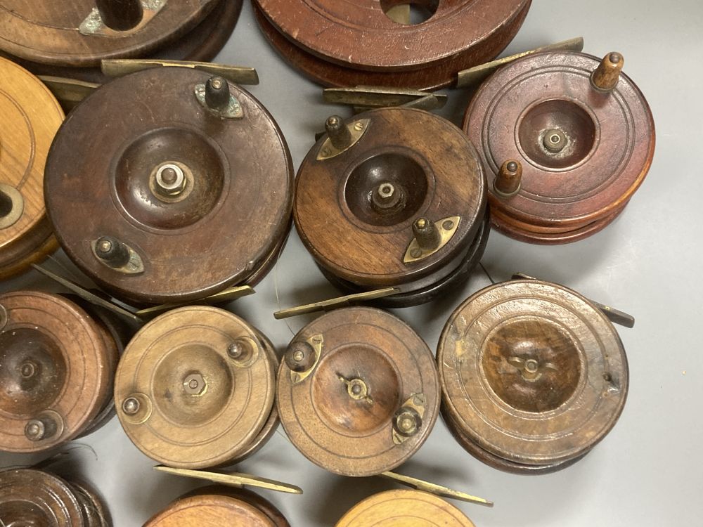 A collection of mahogany and brass fishing reels, largest 17.5cm (14)